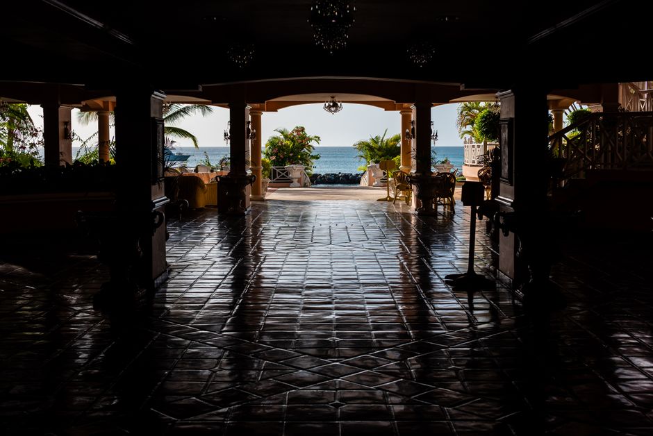 Beautiful view of the Caribbean Sea framed by a patio with reflections on tiled floor.