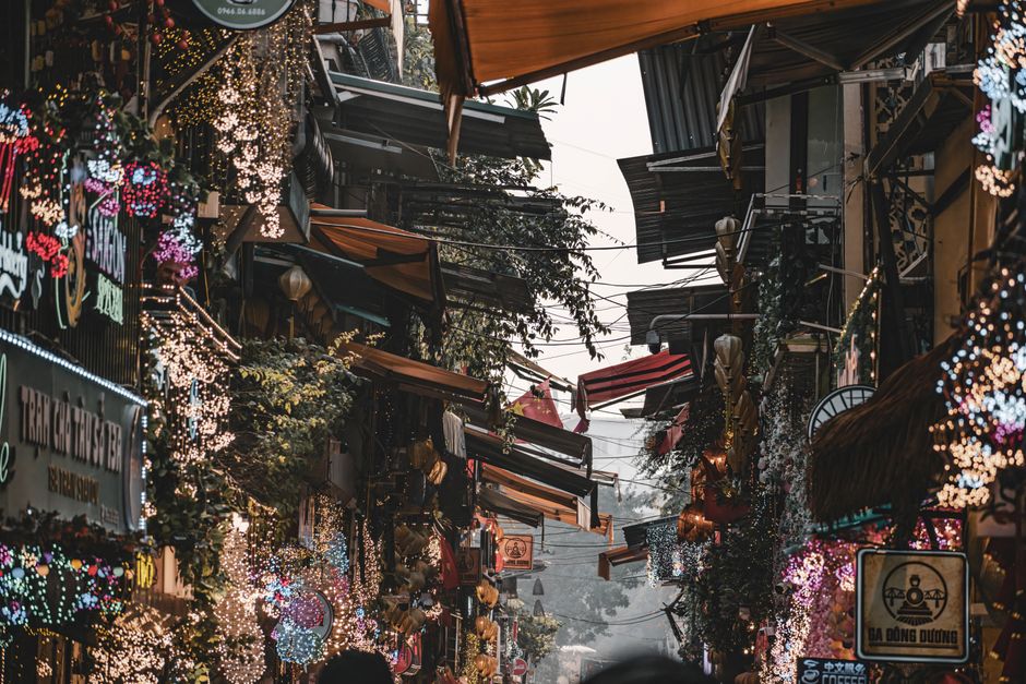 Colorful Hanoi street with bustling activity and festive lights, showcasing Vietnamese culture.