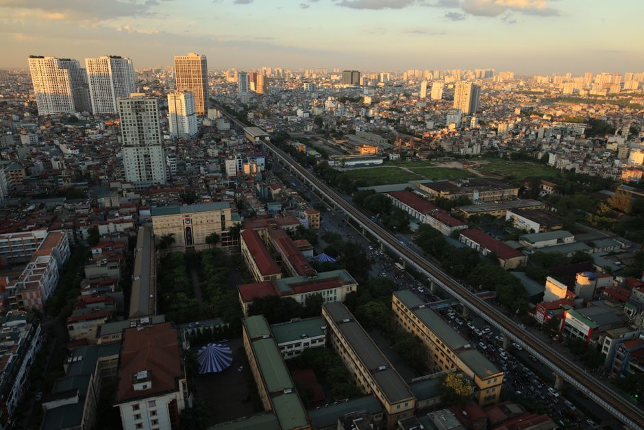A breathtaking aerial view of a bustling cityscape captured during sunset, showcasing high-rise buildings and urban sprawl.