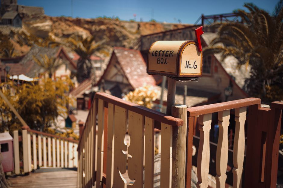 Quaint mailbox overlooking picturesque village scene, ideal for storytelling.