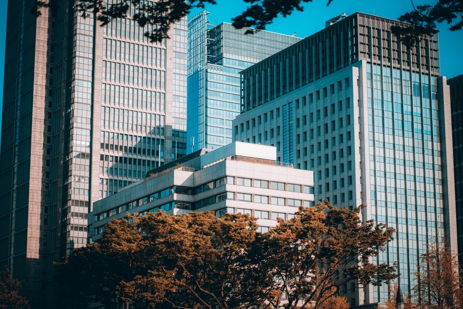 View of modern skyscrapers in Tokyo's bustling financial district with clear blue sky.