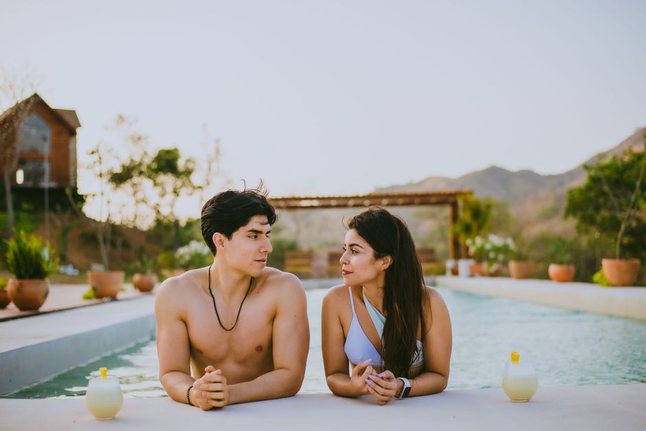 A couple enjoys a relaxing day at a resort pool, capturing summer vibes and tranquility.