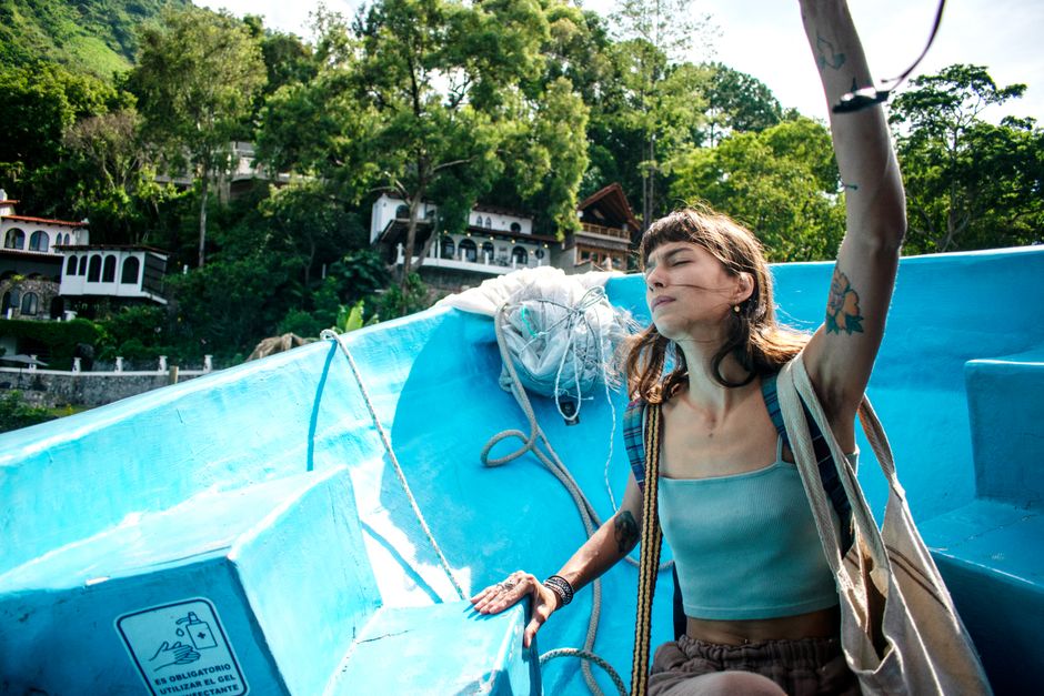 Woman enjoying a serene boat ride in Santiago Atitlán, surrounded by lush greenery.