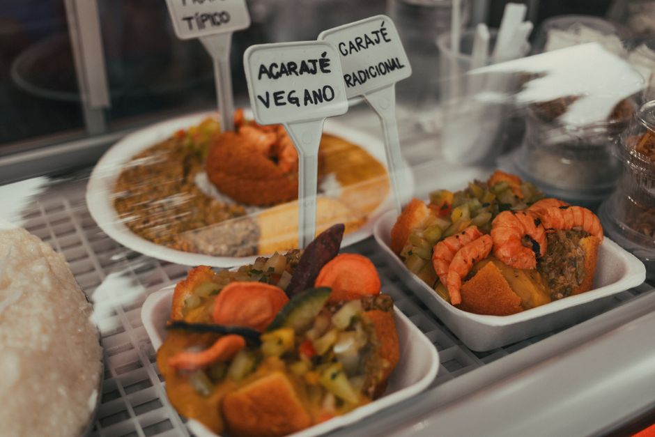 Close-up of acarajé and vegetarian options in a Brazilian display. Perfect for food lovers.