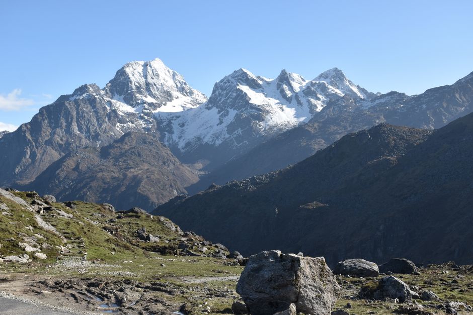 Breathtaking view of towering snowcapped mountains with a blue sky backdrop, capturing nature's grandeur.