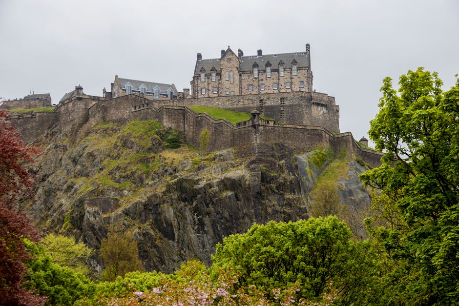 View of Edinburgh Castle surrounded by lush greenery in springtime, Scotland.