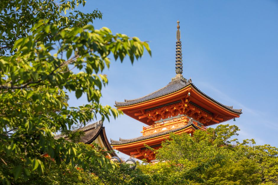 Beautiful view of Koyasu Pagoda surrounded by greenery and clear blue sky in Kyoto, Japan.
