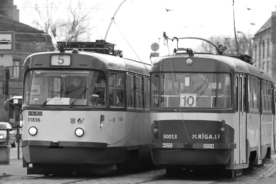 Black and white photograph of vintage trams in Riga, Latvia, showcasing urban transportation.