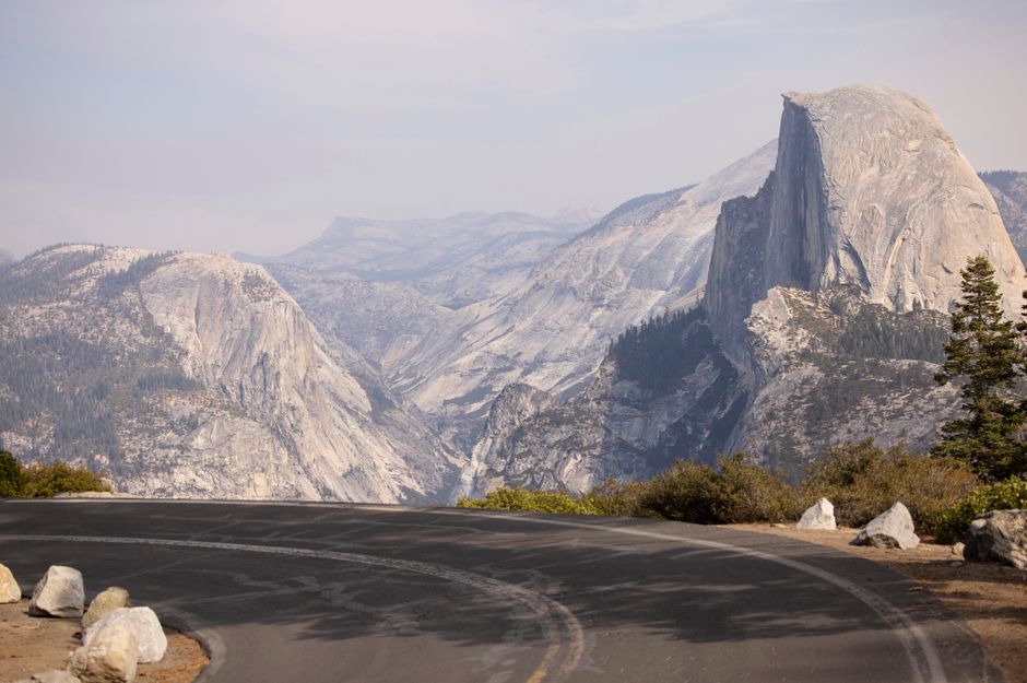 Breathtaking view of Half Dome in Yosemite with a winding road in the foreground.