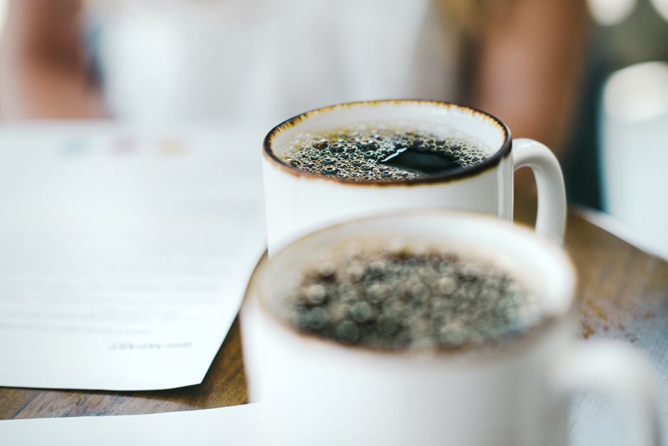 Two mugs of coffee on a table alongside paperwork. Ideal for lifestyle themes.