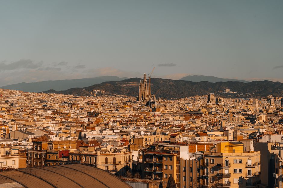 Aerial view of Barcelona with the iconic Sagrada Familia under a clear sky.