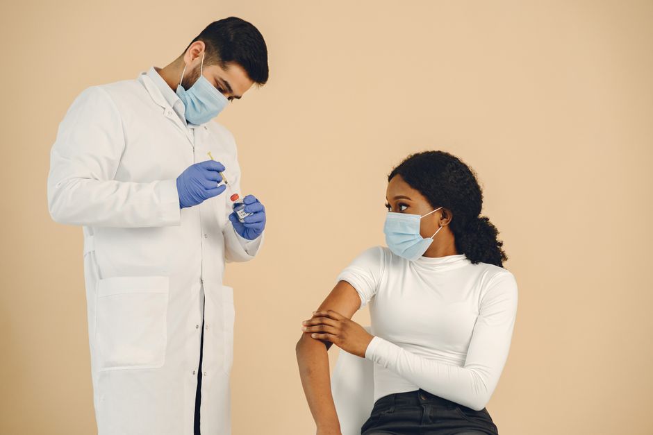A healthcare professional prepares a vaccine dose for administration to a young woman.