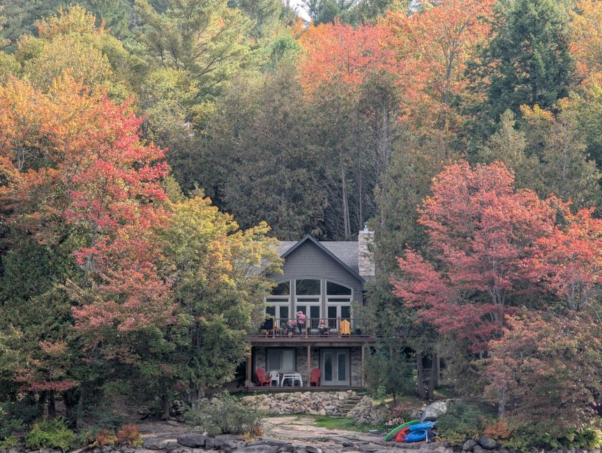Scenic cabin nestled in vibrant autumn forest, perfect for a peaceful retreat.